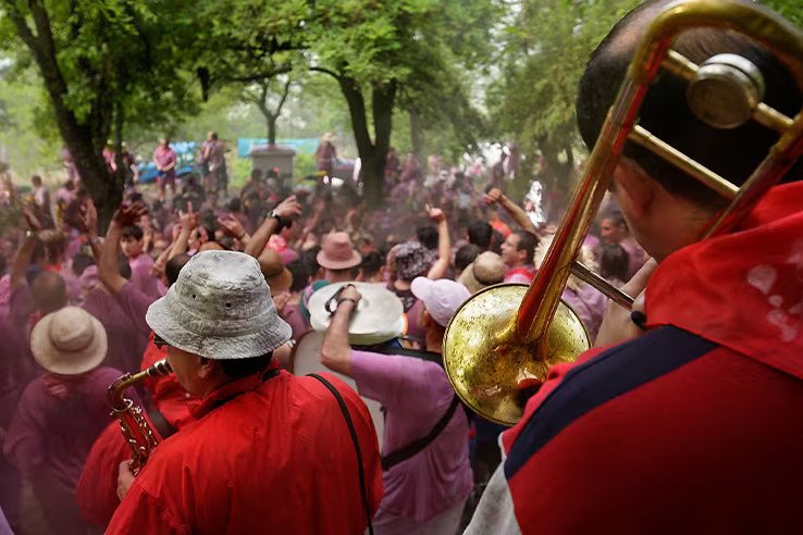 Charanga tocando en la Batalla del Vino de Haro con participantes al fondo disfrutando de la fiesta.